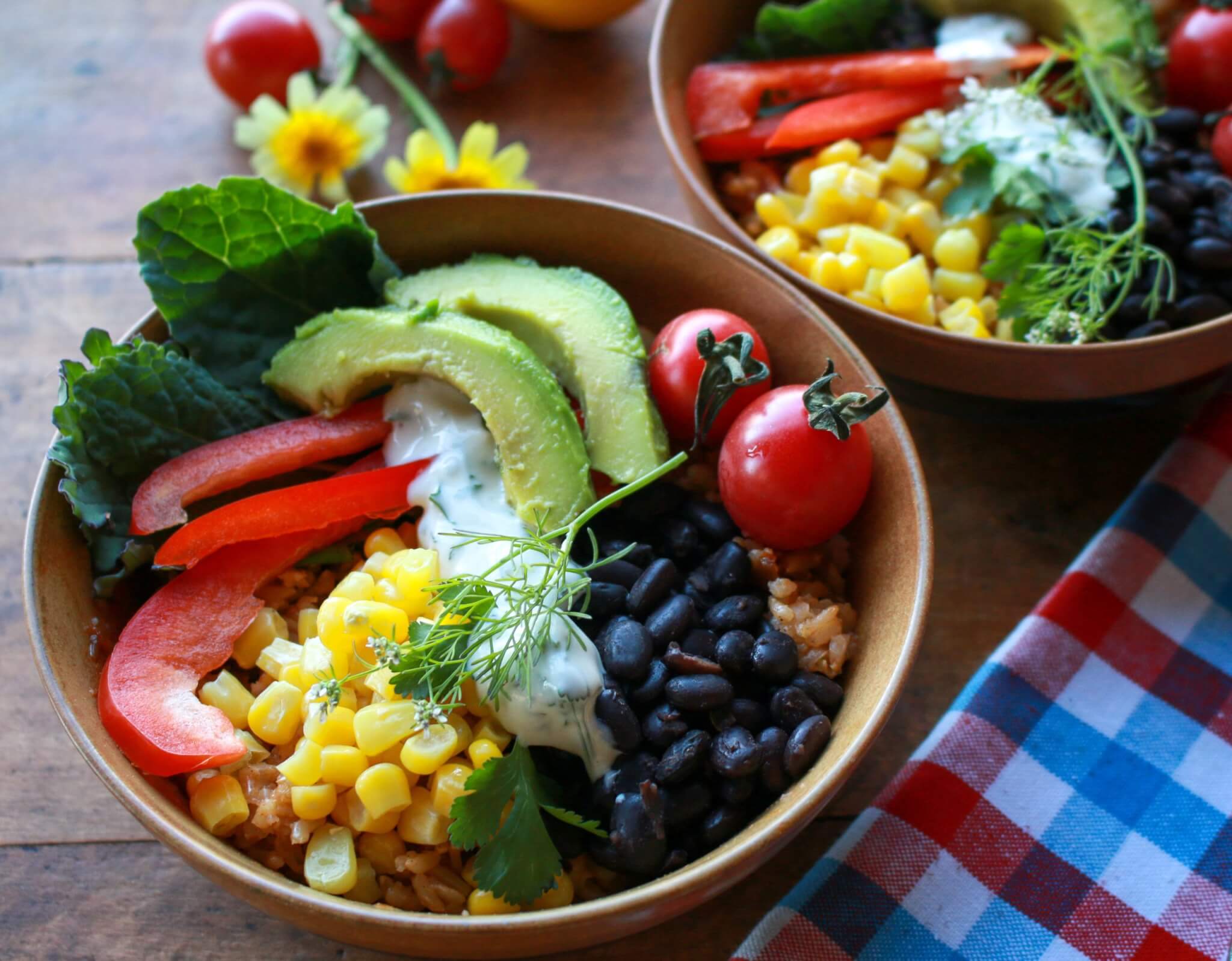Chipotle Tomato Rice Power Bowl topped with avocado, black beans, red bell pepper, corn, tomatoes, and dip